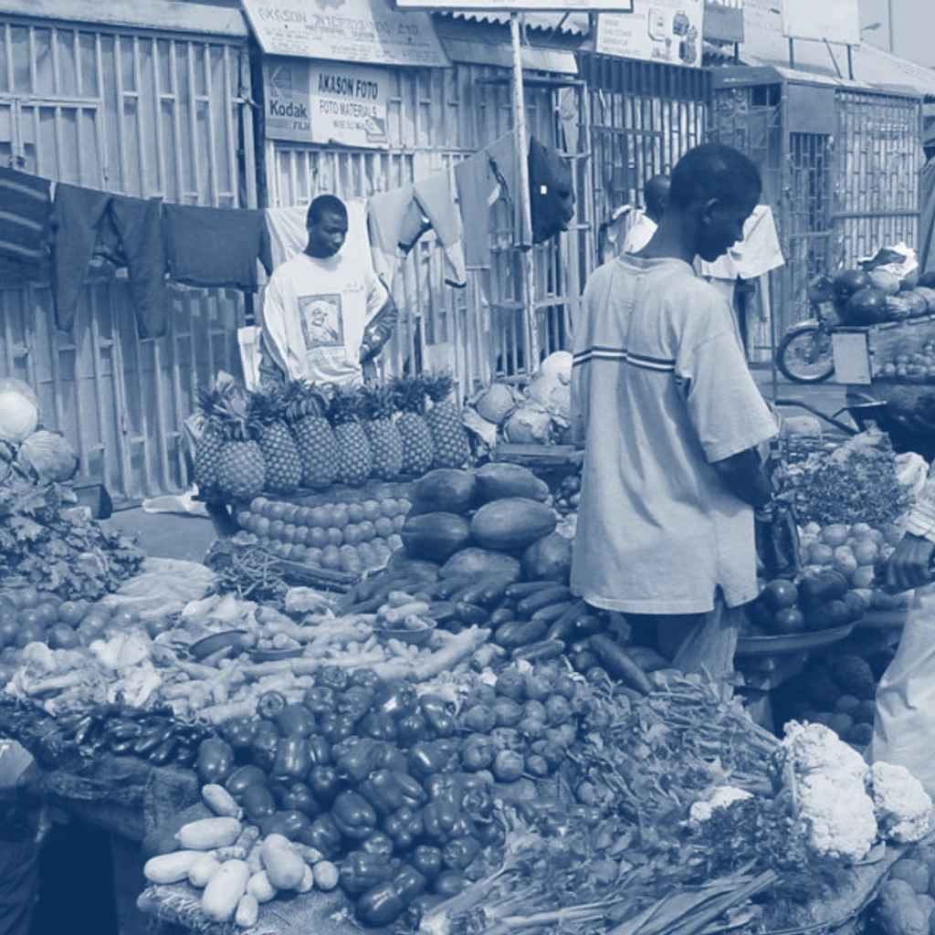 People standing in a market filled with fruit and vegetable