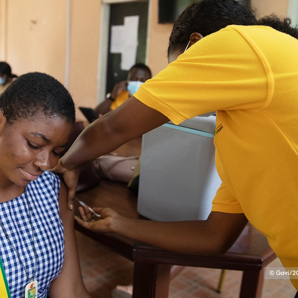 women sat down being given a COVID-19 vaccine