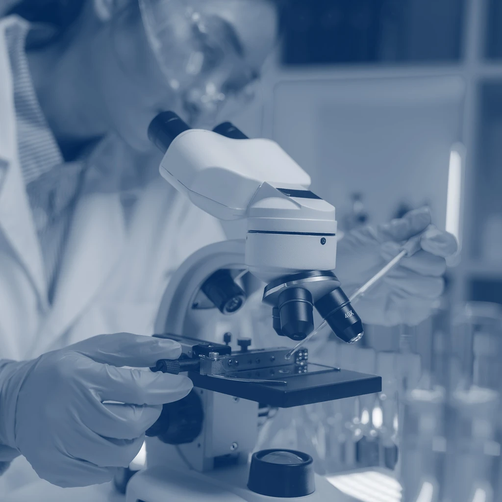 researcher in lab looking into microscope