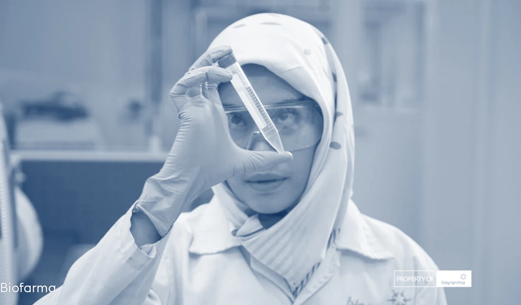 A female scientist from Biofarma holding a vile of vaccine in a lab