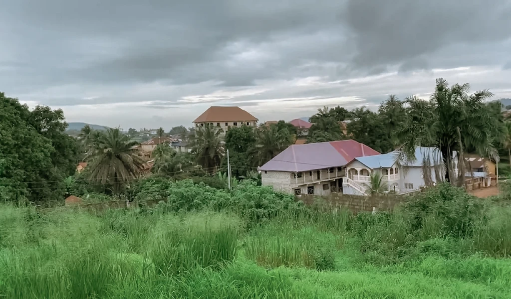 Lush vegetation and houses showing view outside Kenema hospital