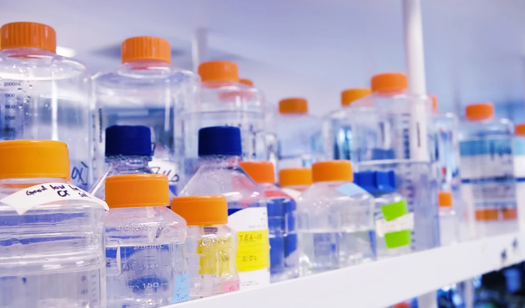 plastic bottles of different size on white shelves
