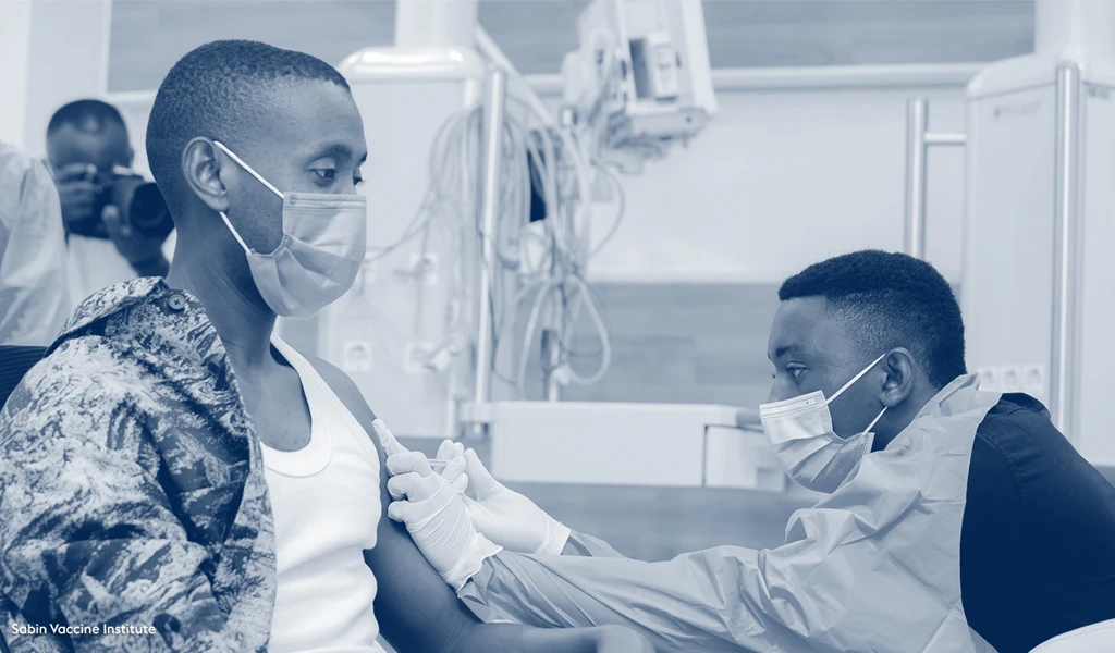 man sat down receiving vaccine from healthworker in PPE