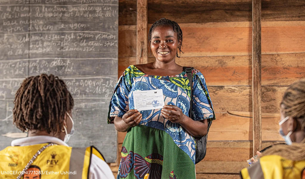 Sauda, a mother of seven, proudly displays her vaccination card after receiving her mpox vaccine at Kabingo Primary School in the Karisimbi health zone, near Goma, in North Kivu province, DR Congo, on 26 March 2025.