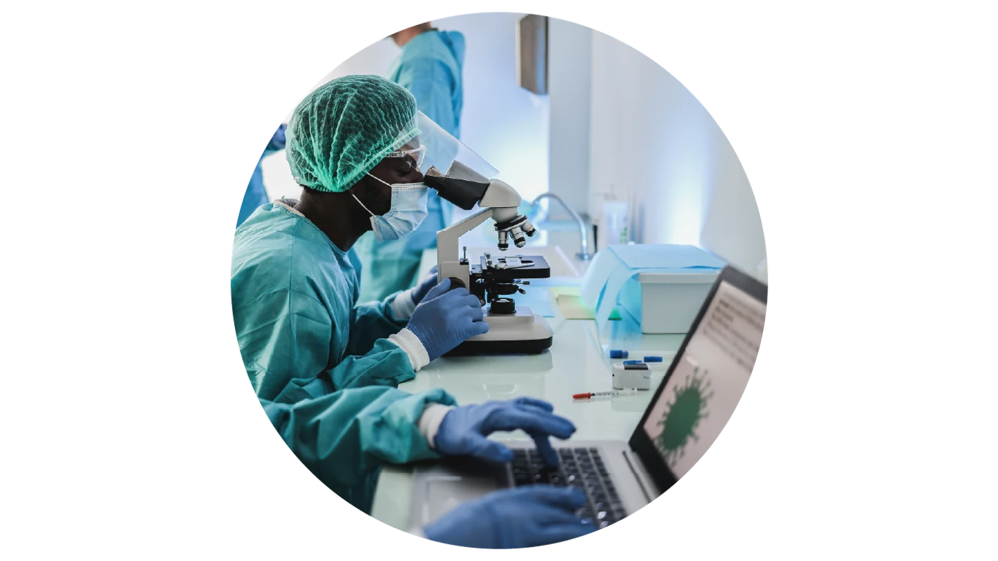 researchers in green PPE looking at computer screen