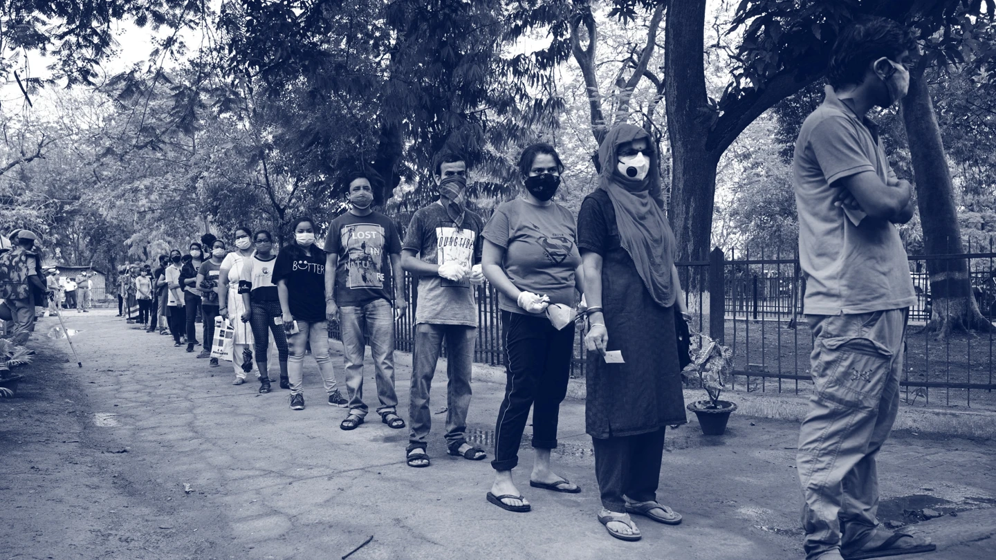 People queueing in a line with facemasks on. Credit: Shutterstock