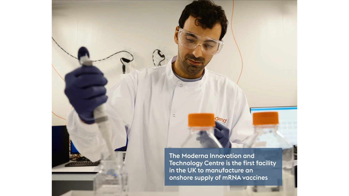 man in PPE working in a white lab room