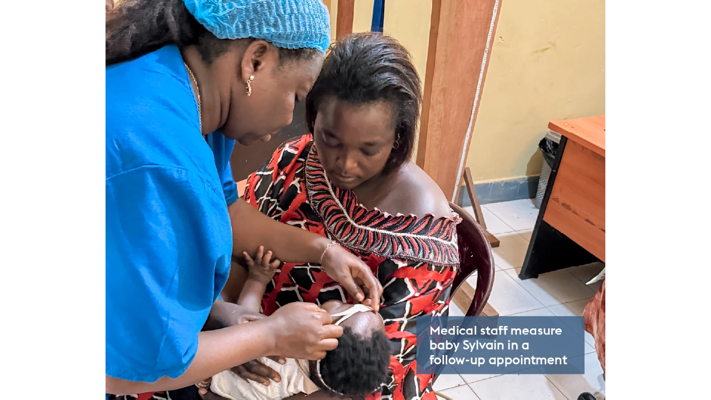 health worker measuring a babies head with a tape measure