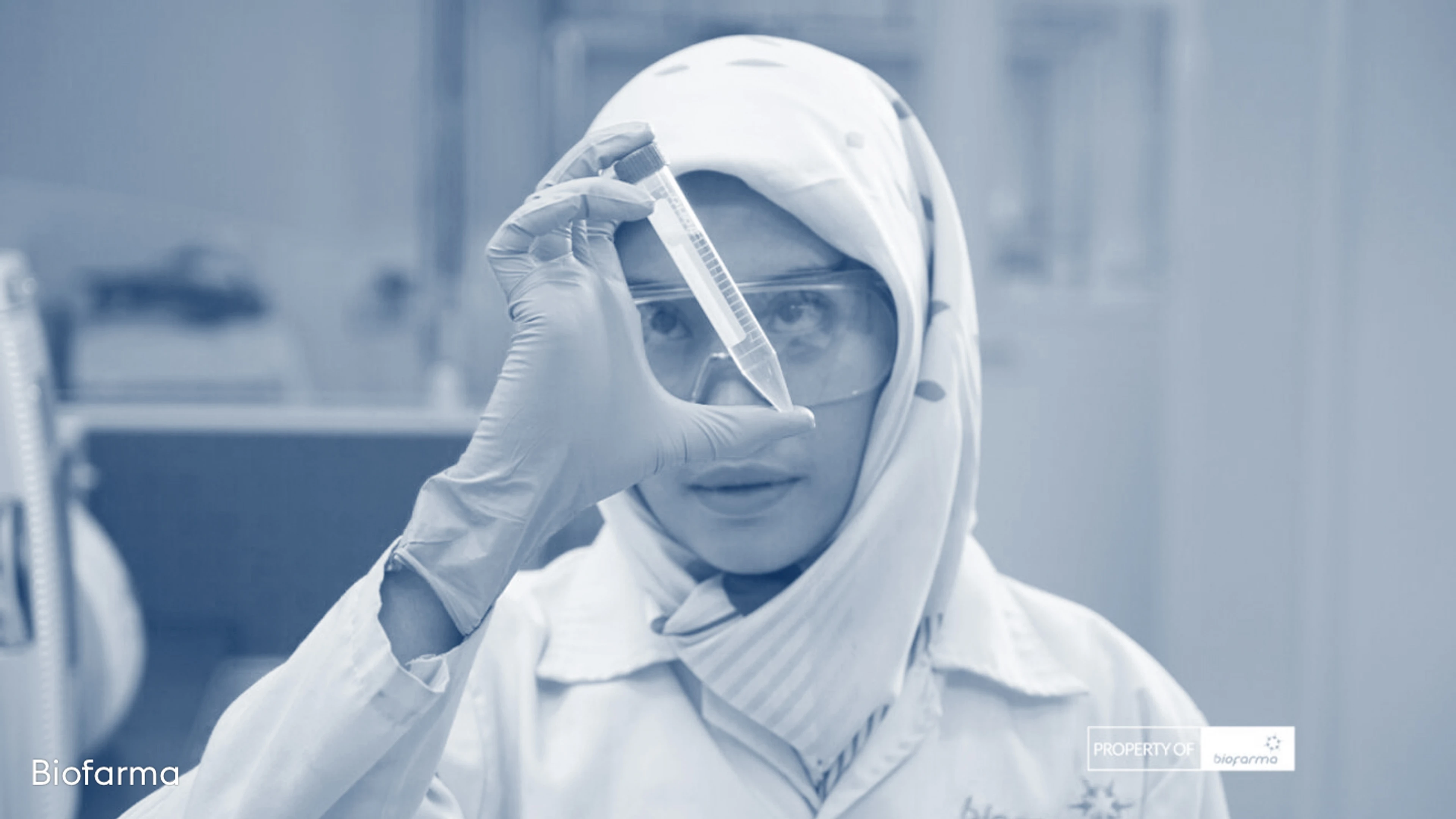 A female scientist from Biofarma holding a vile of vaccine in a lab