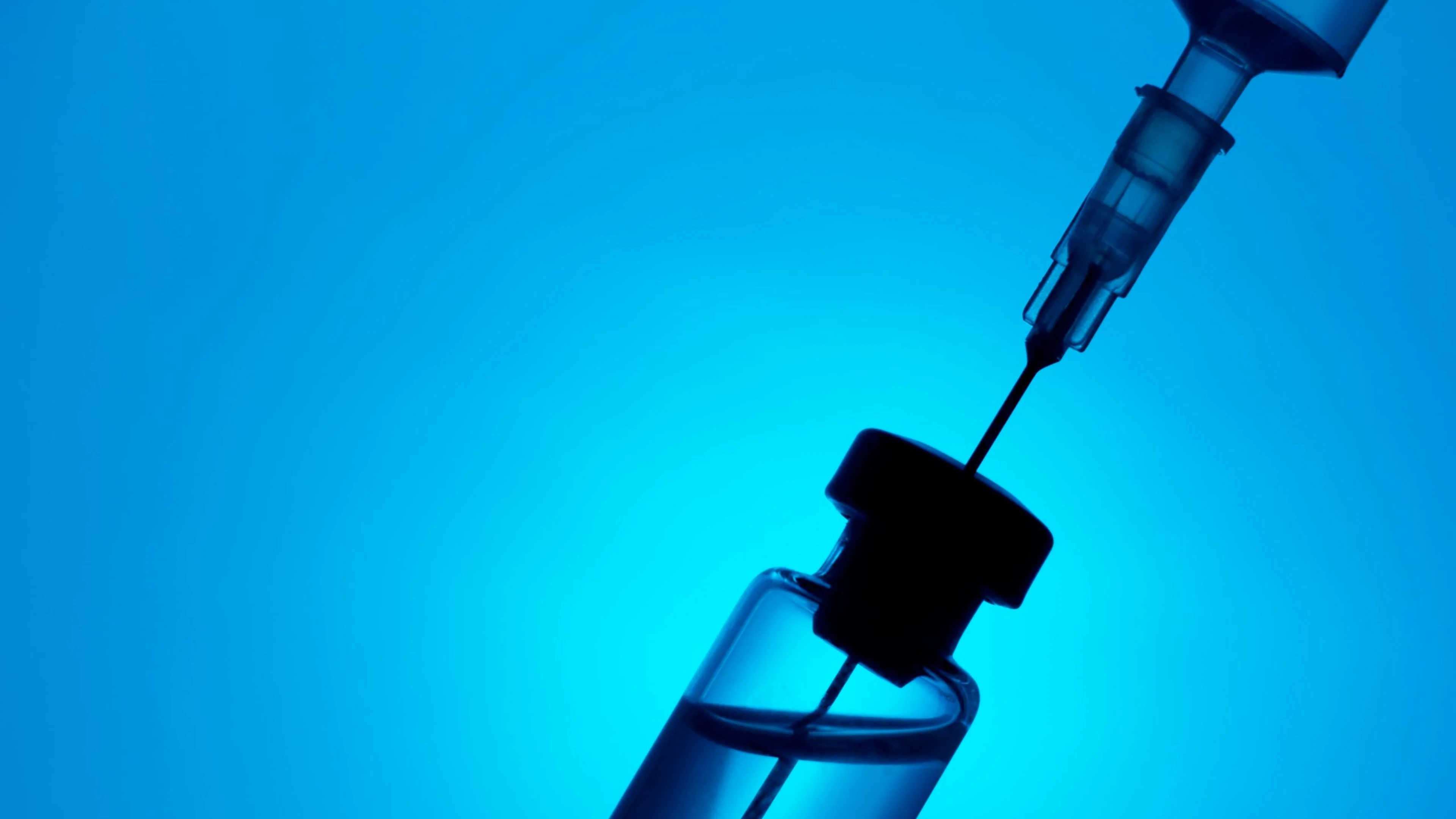 Syringe,And,Medicine,Vial,On,Blue,Background