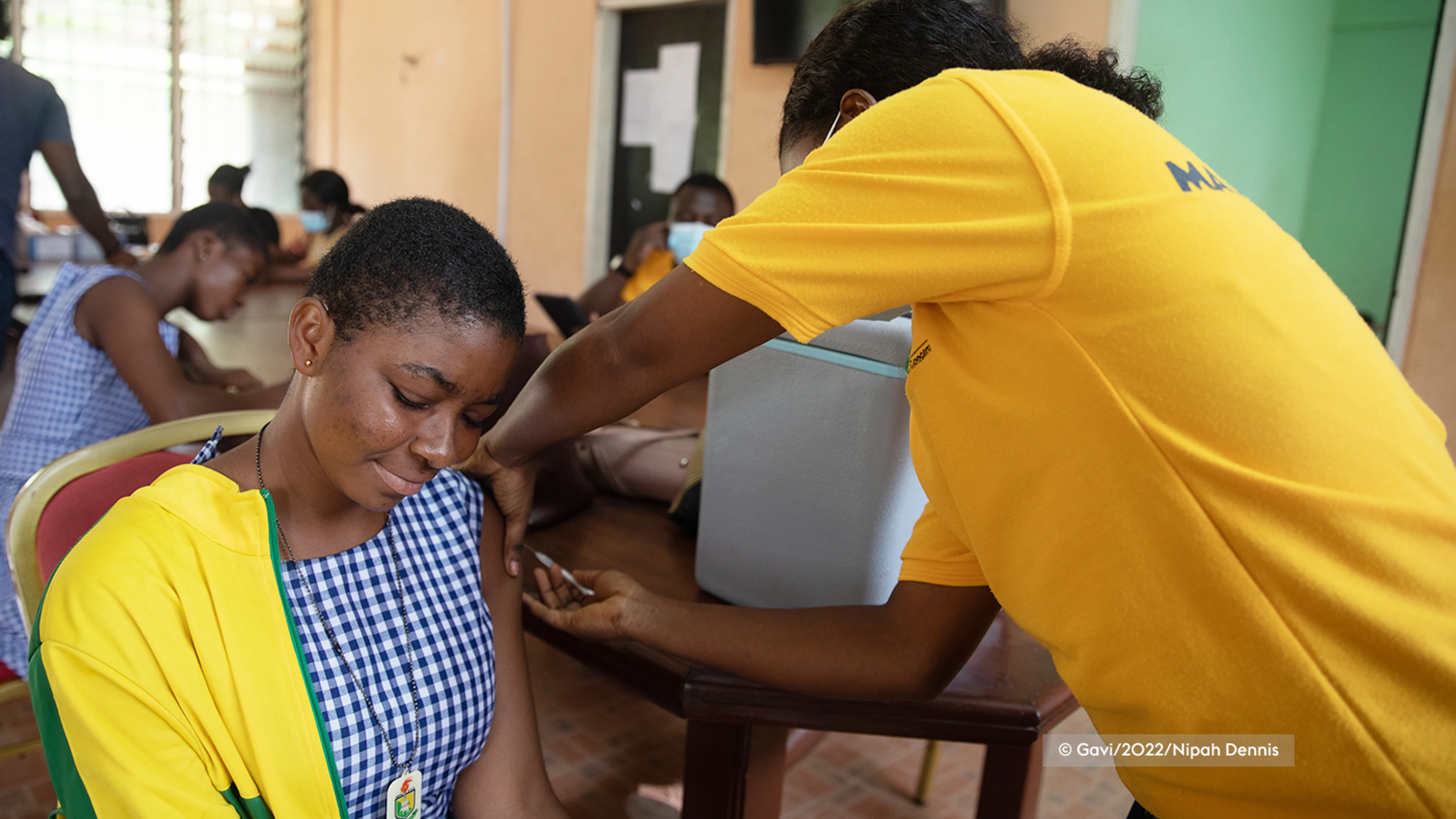 women sat down being given a COVID-19 vaccine