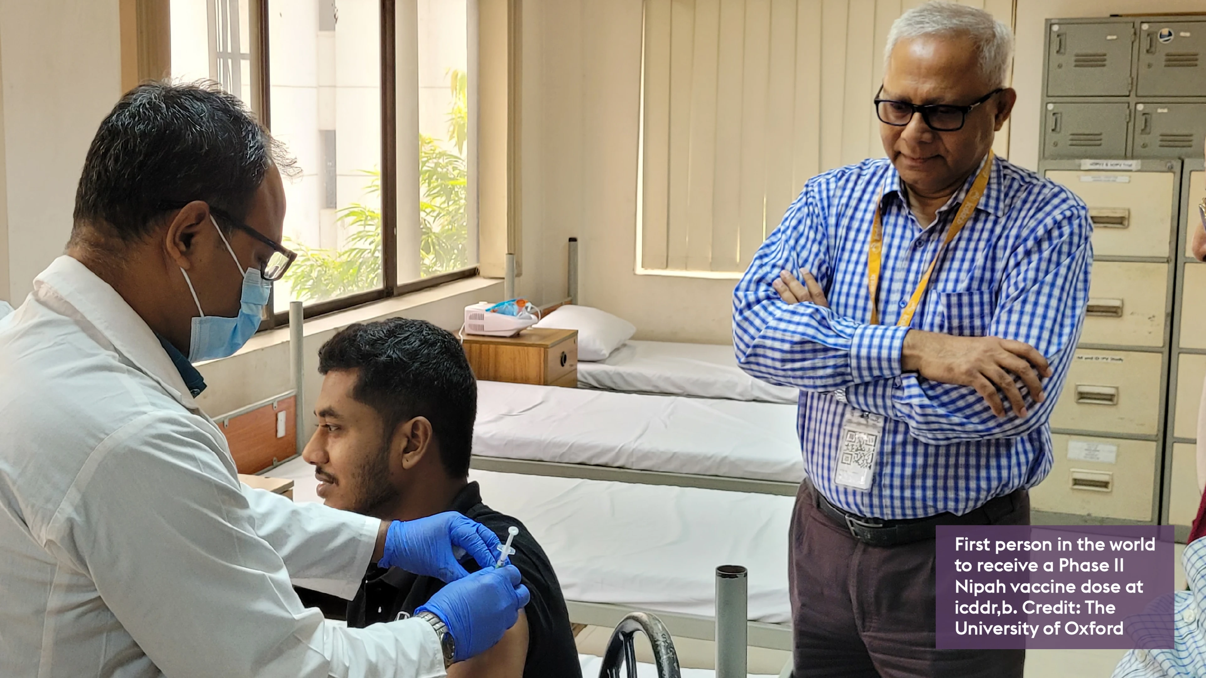 photo of person sat down receiving Nipah vaccine by health worker